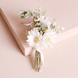 Dorothy Dried Flower Wedding Buttonhole leaning against beige coloured backdrop