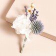 Lavender Dried Flower Wedding Buttonhole on top of pink backdrop