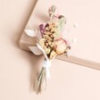 Close up of Margot Dried Flower Wedding Buttonhole outside of beige coloured backdrop