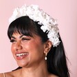 Model wearing White Hydrangea Dried Flower Wedding Headband smiling against pink background