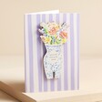 Wooden Bouquet Decoration Purple Striped Greetings Card on top of beige coloured backdrop