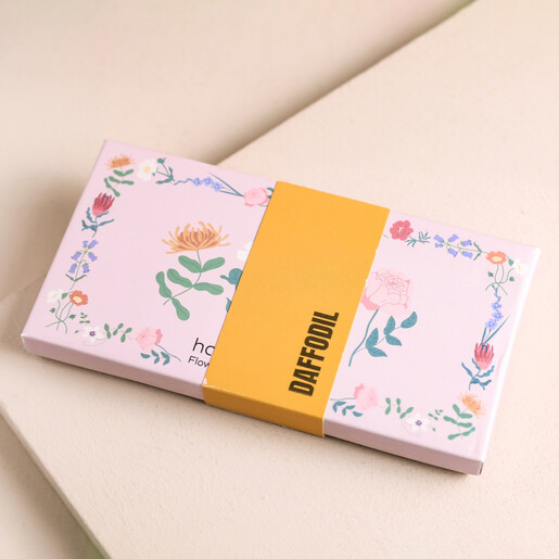 Closed Box of Hana Blossom Daffodil Flower Scented Tealights on Pink Surface