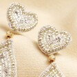 Close up of My Doris Silver Teardrop Heart Beaded Drop Earrings on top of beige coloured fabric