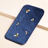 Navy Velvet Bee Glasses Case leaning against beige coloured backdrop