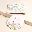 Pink Floral Round Compact Mirror and Pouch on Beige Surface