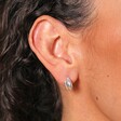 Close Up of Curved Wrap Huggie Hoop Earrings in Silver on Model