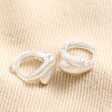 Curved Wrap Huggie Hoop Earrings in Silver on Beige Fabric