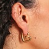Close Up of Large Scribble Heart Hoop Earrings in Gold on Model
