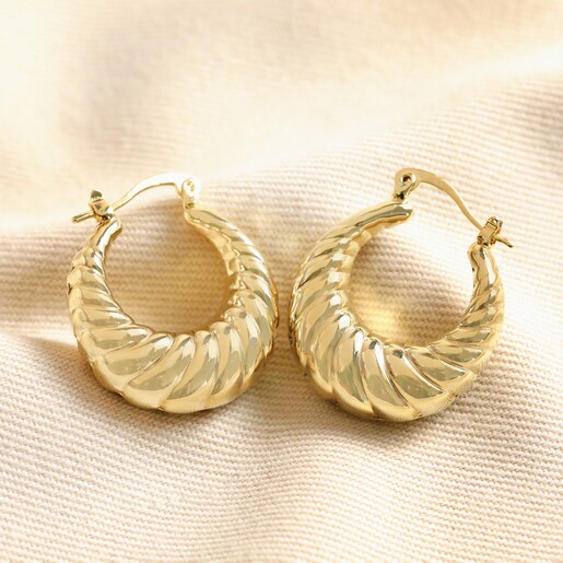 Twisted Rope Creole Hoop Earrings in Gold on top of beige coloured material