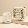 A white candle in a glass container with a 15-hour burn time with a bergamot and tomato scent