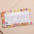 Back label of Arthouse Unlimited Full of Joy Silky Salted Caramel Milk Chocolate Bar on a neutral background