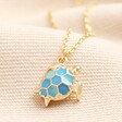 Blue Turtle Pendant Necklace in Gold on a neutral background