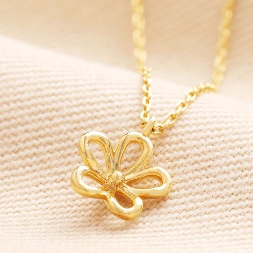 Delicate Flower Outline Pendant Necklace in Gold on a neutral background