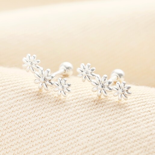 Estella Bartlett Triple Flower Stud Earrings in Silver close up Estella Bartlett Triple Flower Stud Earrings in Silver on a neutral background