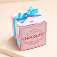 The Chocolate Gift Company Chocolates in light pink and red packaging with a blue ribbon