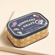 A hand-illustrated sardine tin-inspired candle