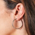 Stainless Steel Slim Hoop Earrings in Silver on a model