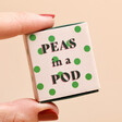 Close up of Tiny Matchbox Ceramic Peas in a Pod Token packaging