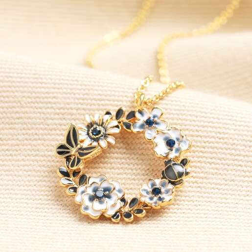 Blue Bee and Flower Circle Pendant Necklace in Gold  Blue Bee and Flower Circle Pendant Necklace in Gold on a neutral background