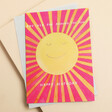 This card features a bold yellow smiling sun illustration