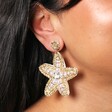 Close Up Model Shot of Bead and Pearl Starfish Drop Earrings in Gold on Model