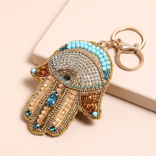 Beaded Hamsa Hand Keyring and Bag Charm against a beige background 