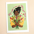 A print of a smiling woman with black hair holding a bouquet of flowers.