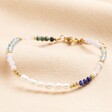 A Blue White and Gold Beaded Bracelet on a Neutral Fabric