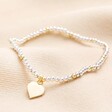 Gold and Silver Beaded Heart Charm Bracelet on a neutral colour background