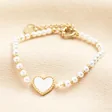 A bracelet made from luxurious pearl beads featuring a romantic shell heart charm detail