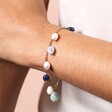 Close Up of Semi Precious Blue Bead and Pearl Charm Bracelet in Gold on Model