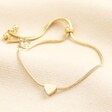 A gold bracelet with a heart charm