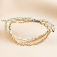 Stainless Steel and Turquoise Beaded Double Layer Cord Bracelet in Gold on a neutral background