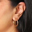 Close Up of Stainless Steel Hammered Hoop Earrings in Gold on Model