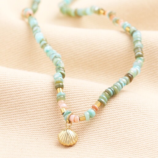 Green Two Way Shell Charm Beaded Necklace and Bracelet in Gold  A two-way necklace or stack of bracelets In a combination of green and gold beads.