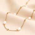 Stainless Steel Pearl and Ball Long Chain Necklace in Gold on neutral background