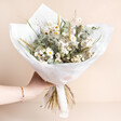 Mabel Bridal Bouquet with a selection of light coloured dried flowers wrapped in white paper on a neutral background