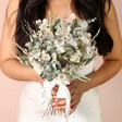 Mabel Bridal Bouquet with a selection of light coloured dried flowers being held by model 