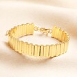 A gold bracelet with layered vertical bars with rectangular bars varying in lengths.