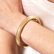 Close Up of  Thick Open Chunky Torque Bangle in Gold on Model