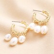 Triple Pearl Drop Rope Hoop Earrings in Gold on a beige material 