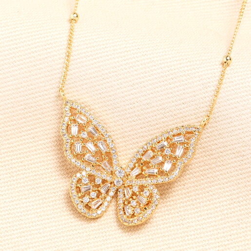 A Large Gold Pendant in the Shape of a Butterfly with Outstretched Wings and Sparkly Details
