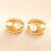 A Tiny Pair of Shell-Shaped Stud Earrings in Gold With Textured Details and Tiny Pearls
