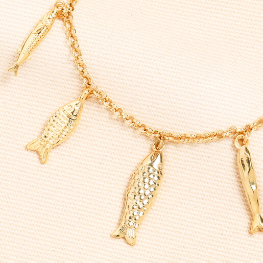 A Close Up of Fish Shaped Charms Suspended from Chain Bracelet