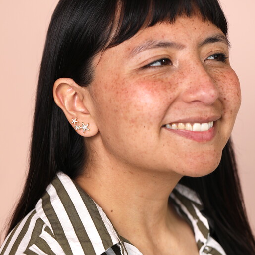 model with climber stud earrings in gold