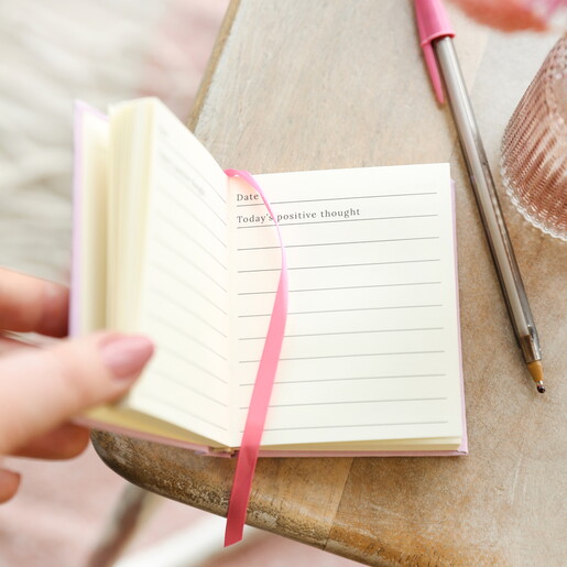 pink mini notebook against a pale pink backgrou
