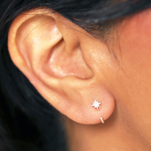 Close up of Sterling Silver Thread Through Star Huggie Hoop Earrings On Model