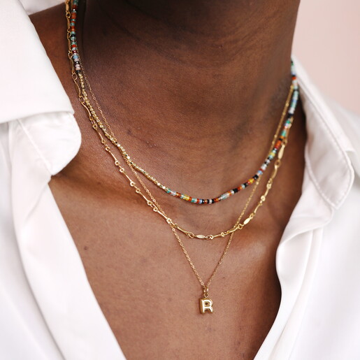 rainbow necklace against pale pink background