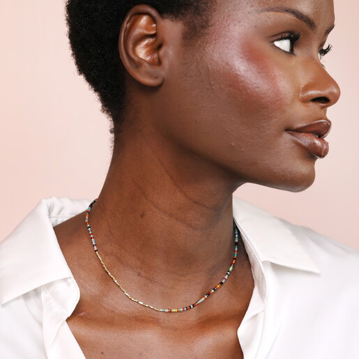 rainbow necklace against pale pink background