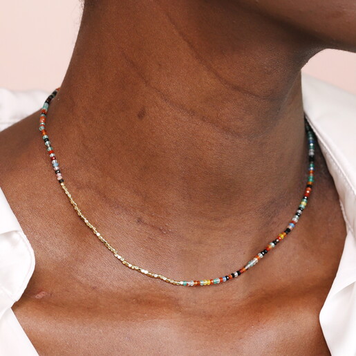 rainbow necklace against pale pink background